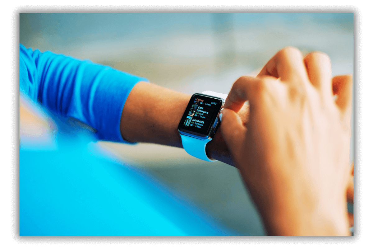 Hands checking notifications on a blue smartwatch, wearing a sky blue t-shirt.